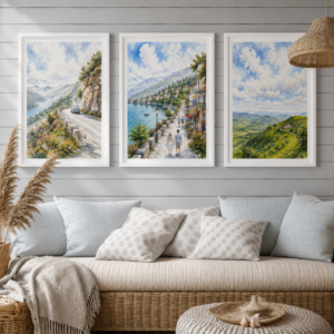 Set of three landscape watercolor prints in white frames — mountain road, lakeside town, and rolling hills